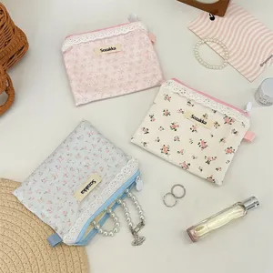 Vue détaillée de petites pochettes en coton à fleurs avec une bordure en dentelle blanche