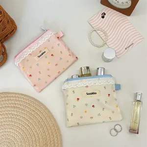Vue détaillée de petites pochettes de rangement à fleurs et dentelle pour écouteurs