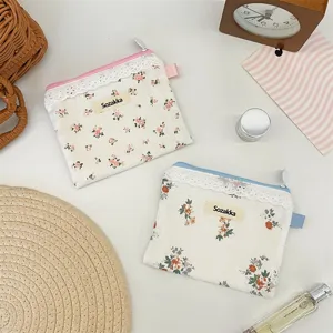 Détail de petites pochettes de rangement fleuries avec bordure en dentelle pour accessoires