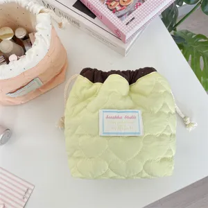 Vista detallada del neceser de maquillaje acolchado con corazones y cordón en verde claro