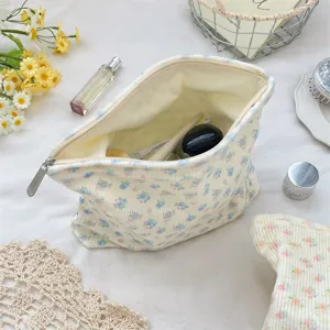 Close-up of creamy corduroy makeup bag with floral print showing spacious interior