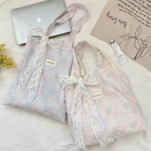 Detail view of pink and blue plaid canvas tote bags with large white lace bows