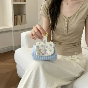 Close-up of a floral quilted coin purse with a pink contrast button for small items.