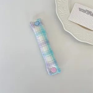Dettaglio organizer per cavi a quadri macaron con bottone a pressione a cuore blu