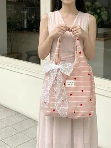 Pink and white striped tote bag with heart embroidery and a large lace bow detail.