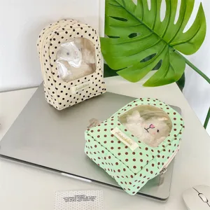 Close-up detail of polka dot doll storage bag with a transparent window for display.