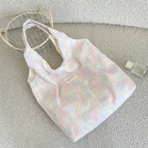 Close-up flat lay of pink and blue patchwork plaid canvas tote bag for daily commute