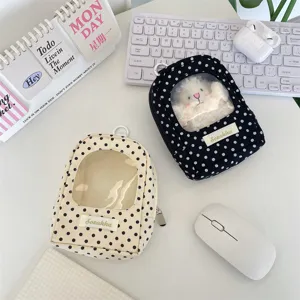Close-up detail of mini polka dot doll display bag with transparent window and zipper.
