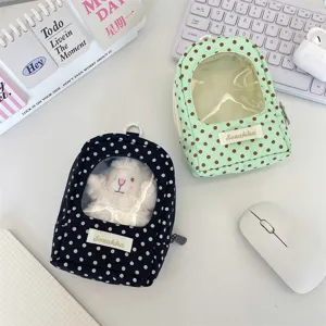 Detailed view of polka dot doll display bags with clear windows on a desk