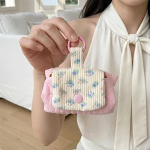 Detailed view of a pink quilted floral coin purse held by hand for lipstick storage