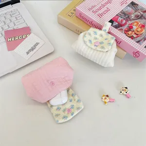 Detailed view of quilted floral storage pouch with earphones and snap button closure