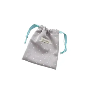 Grey satin polka dot drawstring bag with blue ties for jewelry and accessory storage