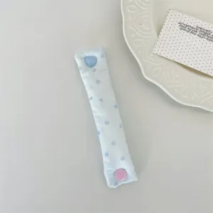Dettaglio di un ferma cavo in tessuto azzurro con stelle e bottone a pressione a cuore