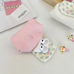 Close-up detail of quilted pink mini pouch with snap button and floral lining for earbuds