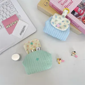 Aesthetic quilted floral mini storage pouch for lipstick and earphones shown on desk
