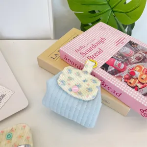 Detailed view of the light blue quilted floral pouch with a pink snap closure