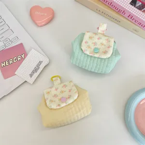 Detailed macro shot of floral quilted coin pouches for lipstick and earphone storage