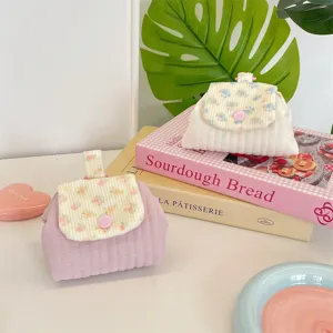 Close-up detail of quilted floral mini storage pouch for lipstick and headphones