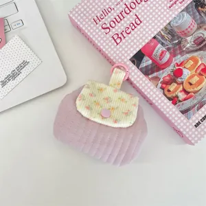 Floral quilted coin purse detail showing pink snap button and lavender fabric texture.