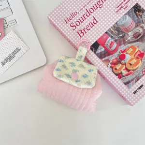 Close-up of floral quilted coin purse with snap button for lipstick and earphones