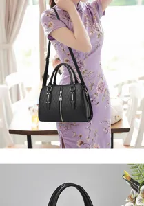 Large capacity black diamond quilted handbag carried by a model in a purple floral qipao