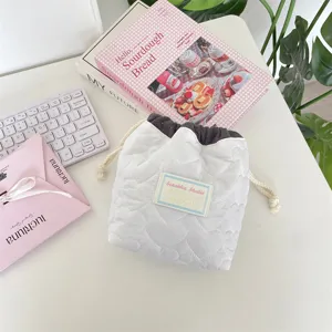 Vista detallada de bolsa de cosméticos blanca acolchada con corazones y cordón