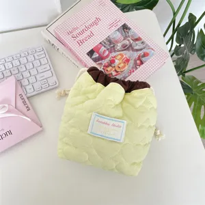 Bolsa amarilla acolchada de corazones con cordón para cosméticos y lápices labiales.