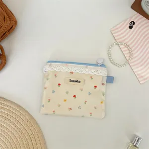 Pochette de rangement florale crème avec fermeture éclair bleue et détails en dentelle