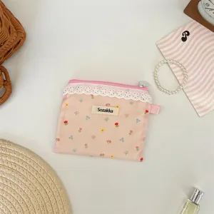 Vue détaillée d'une petite pochette de rangement rose à fleurs et dentelle avec fermeture