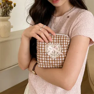 Brown plaid quilted cosmetic bag with lace heart bow detail, perfect for daily portable storage.