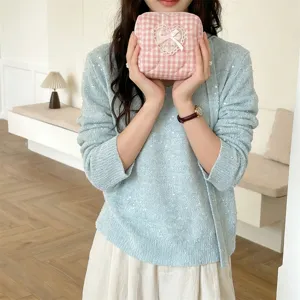 Close-up detail of the pink plaid quilted cosmetic pouch featuring sweet lace heart and bow.
