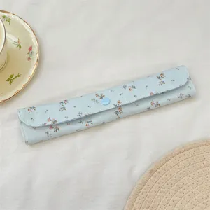 Detalle de bolsa para cubiertos con estampado floral, estuche de tela portátil con botón.