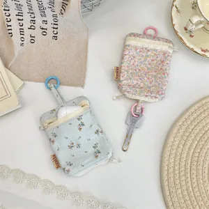 Detailed shot of cute floral key pouch with double zippers and metal hook, ideal for storage.