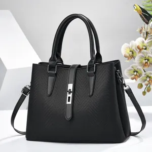 Elegant black women handbag detail, woven texture leather, metal lock closure, shoulder strap.