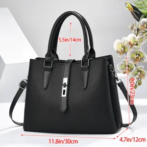 Detailed view of the black leather top handle bag showcasing texture, lock, and dimensions.