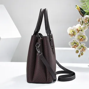 Textured brown shoulder handbag detail showcasing premium material and multi-compartment design.
