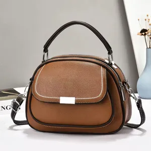 Detailansicht einer braunen Handtasche aus genarbtem Leder mit mehreren Reißverschlussfächern