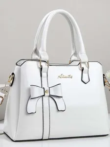 Elegant white patent leather tote bag for women with decorative bow and gold hardware.