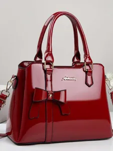 Elegant red patent leather handbag with bow decoration and top handles