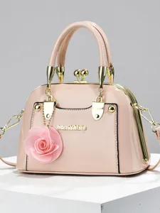 Borsa a tracolla a conchiglia in vernice elegante con ciondolo floreale per uso quotidiano.
