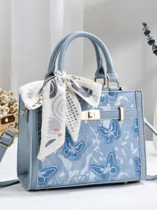 Lichtblauwe dames handtas met vlinder kant motief en een stijlvolle zijden sjaal accessoire.
