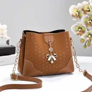 Elegante borsa a secchiello marrone da donna con stampa a stelle e catena dorata.