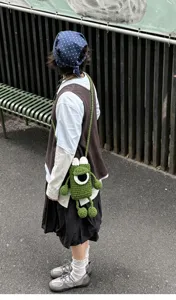 Handmade crochet cute green one-eyed monster crossbody phone bag for women and kids daily use.