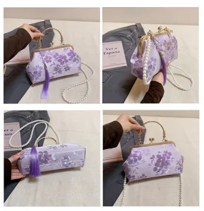 Detailansicht einer eleganten lila blumigen chinesischen Abendtasche mit Perlenkette.
