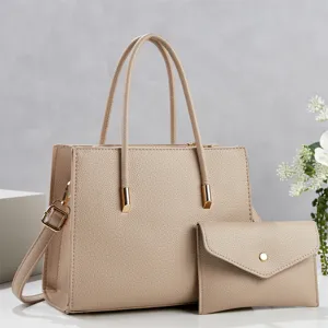 Beige leather tote bag detail with matching pouch, textured PU leather surface and gold hardware.