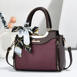 Detailed view of women fashion tote handbag with elegant printed silk scarf and metallic logo.