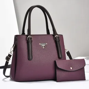 Close-up view showing the textured purple leather and metallic logo detail of the bag.