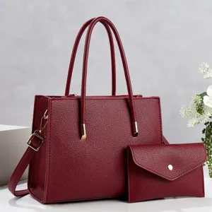 Detail view of the stylish wine red leather tote bag with matching clutch purse and hardware accents.