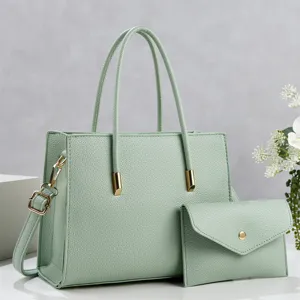 Detailed view of mint green PU leather tote bag with matching clutch and gold hardware.