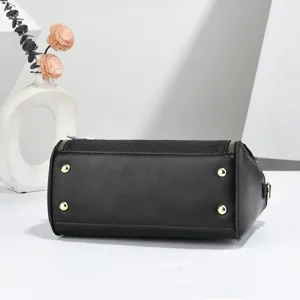 Classic black cylindrical handbag with gold metal feet, elegant design for women style.